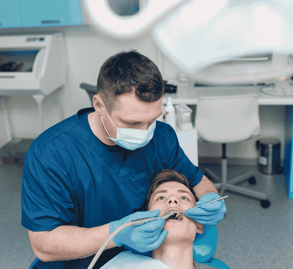 Dentist applying fluoride treatment to a teenage patient